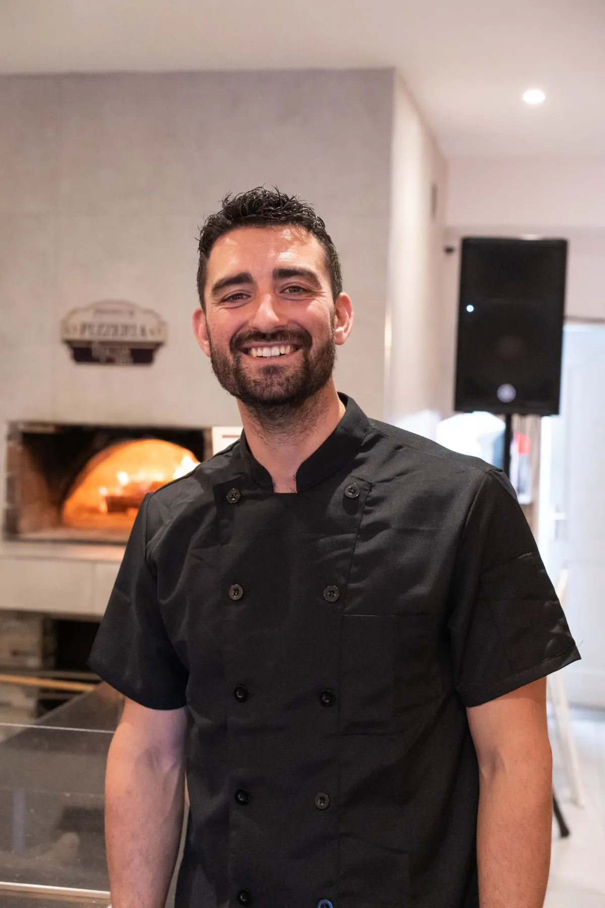 Jo, propriétaire du restaurant Au Feu de Bois à Hyères, devant le four à bois
